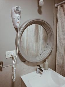 a bathroom with a blow dryer next to a mirror at Maju in Neuquén +4 photos