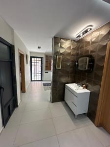 a large bathroom with a sink and a mirror at Apprt Saidia berqia in Saïdia
