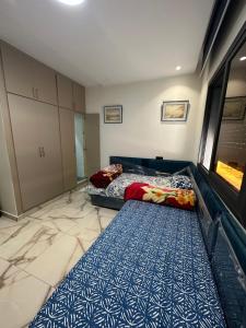 a bedroom with two beds and a blue and white carpet at Apprt Saidia berqia in Saïdia