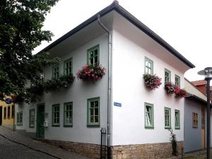 ein weißes Gebäude mit Blumen an den Fenstern in der Unterkunft Ferienwohnung Wenzlaff in Arnstadt