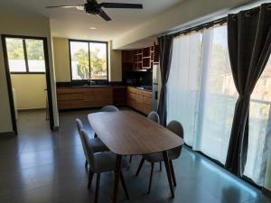 a kitchen with a wooden table and chairs in a room at Departamento Huatulco 1 Torre Bel in Santa Cruz Huatulco +7 photos