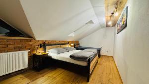 a bedroom with a bed and a brick wall at Apartmany FABRIK in Vysoká nad Kysucou