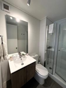 a bathroom with a sink and a toilet and a shower at Live Epicentro in Temuco