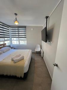 a bedroom with a bed with two towels on it at Live Epicentro in Temuco