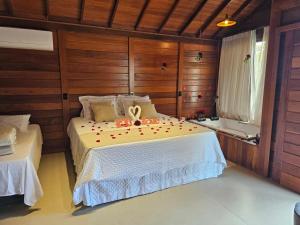 a bedroom with a bed with a ribbon on it at Chales Vista da Mata 01 in Santa Teresa