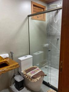a bathroom with a toilet and a glass shower at Chales Vista da Mata 01 in Santa Teresa +15 photos