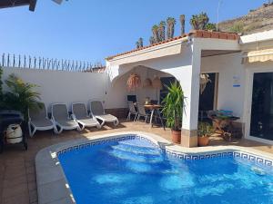 a swimming pool in front of a house at Beautiful Holiday Villa with heated private pool, Los Cristianos in Los Cristianos