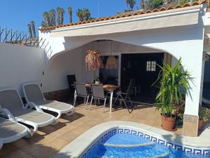 a patio with a table and chairs and a pool at Beautiful Holiday Villa with heated private pool, Los Cristianos in Los Cristianos