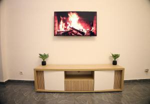 a tv on a wall with a fire on it at Appartement Moderne Centre ville BZV in Brazzaville