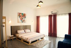 a bedroom with a bed and a painting on the wall at Appartement Moderne Centre ville BZV in Brazzaville