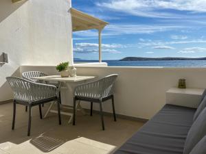 a table and chairs on a balcony with the ocean at Kleanthi Apartments in Drios