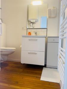 a white bathroom with a sink and a toilet at Studio Villa Agathe in Troyes