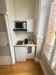 a small kitchen with a sink and a microwave at Studio Villa Agathe in Troyes +7 photos