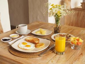 a breakfast table with eggs and toast and oranges and juice at Lombok Hotel & SPA antes Hotel Casablanca in Guaduas