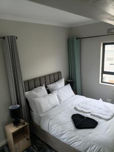 a bedroom with a large bed with white sheets and pillows at Coastal Guest House with Free Parking and Braai Area in Cape Town