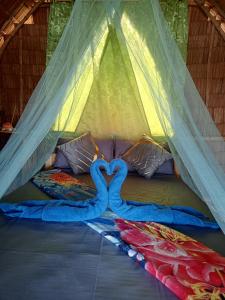 two swans laying on a bed in a tent at Tress Maria's beach resort in Brother Islands