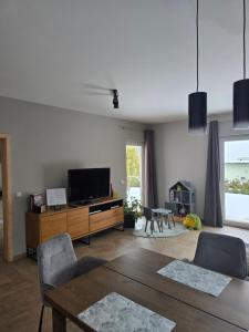 a living room with a television and a table and chairs at Ferienhaus Fliederhain in Stollberg