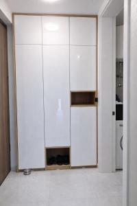 a room with a white closet with shoes in it at Lana Apartmani Autor in Tuzla