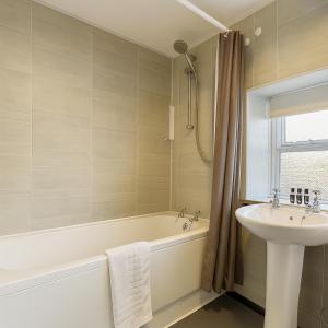 a bathroom with a sink and a bath tub and a sink at The Hand Hotel in Chirk +74 photos