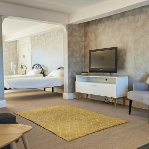 a bedroom with two beds and a television on a wall at The Hand Hotel in Chirk