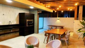 a kitchen and dining room with a wooden table and chairs at Apto alto padrão com vista panorâmica a 100m de Ponta Verde & Pajuçara in Maceió