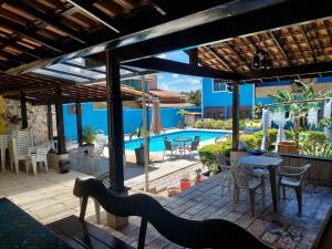 a patio with a table and chairs and a pool at Pousada Summer Beach by Itaúna in Saquarema