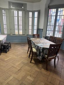 a dining room with a table and chairs and windows at Familyhostel in Santiago