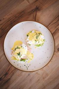 a white plate with eggs on a wooden table at Mish Mish in Tamraght Ouzdar