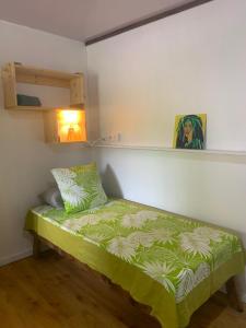 a small bed in a room with a green blanket at Kura Ora Guest House in Rangiroa +16 photos
