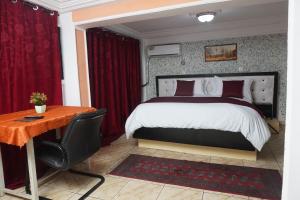 a bedroom with a large bed and a desk at Complexe A8CLOS in Douala