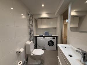 a bathroom with a toilet and a washing machine at Siam Homestay in Mölndal +23 photos