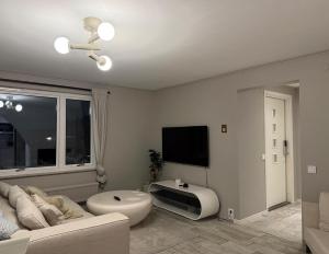 a living room with a couch and a tv at Siam Homestay in Mölndal