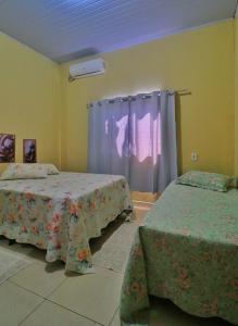 a bedroom with two beds and a window at Lolt Vila Boa Goiás in Goiás