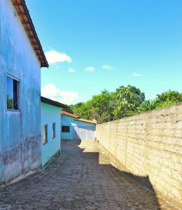 a brick alley way next to a wall at Lolt Vila Boa Goiás in Goiás