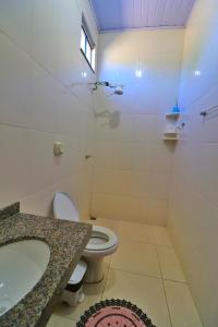 a bathroom with a toilet and a sink and a tub at Lolt Vila Boa Goiás in Goiás