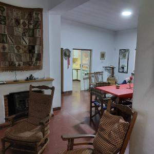 a living room with a table and chairs and a fireplace at Casona El Olivo in Villa Krause