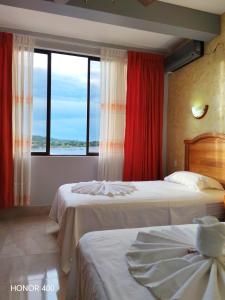 a hotel room with two beds and a window at Hotel Pampa & Selva in Rurrenabaque +95 photos