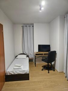 a bedroom with a bed and a desk and a chair at Дунав билдингс 3 in Pleven