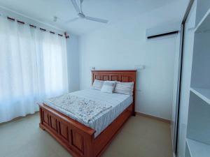 a bedroom with a wooden bed in a room at Bustani Villa in Nyamanzi Kazole