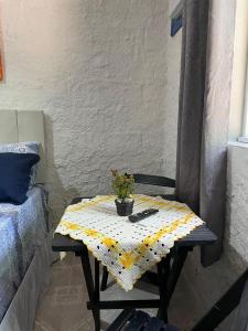 a small table with a plant on it next to a bed at Suítes Sabor e Mar in Angra dos Reis +49 photos
