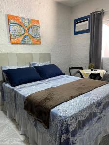 a bed in a bedroom with a painting on the wall at Suítes Sabor e Mar in Angra dos Reis