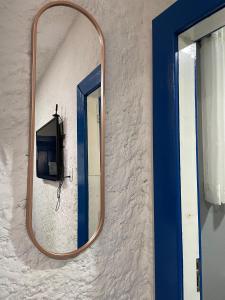 a mirror on the side of a wall with a tv at Suítes Sabor e Mar in Angra dos Reis