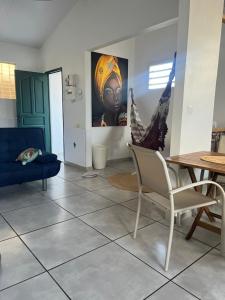 a living room with a blue couch and a table at La maison de Vénus - Petite maison créole à 3 min du front de mer - proche de la plage de la Pointe Faula - kitesurf et activités nautiques in Le Vauclin +11 photos