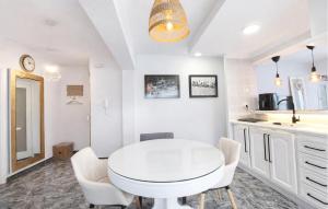 a white kitchen with a white table and chairs at Marisol Molina in Sueca