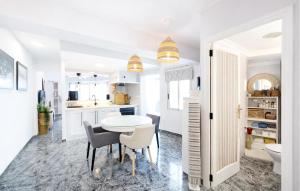 a white kitchen with a table and chairs at Marisol Molina in Sueca