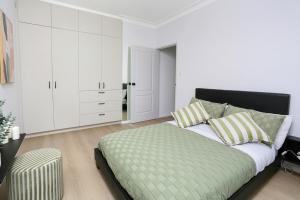 a white bedroom with a bed and white cabinets at The Modern Retreat in Sydney