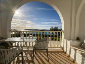 a balcony with a table and chairs and a view of the ocean at Kleanthi Apartments in Drios