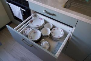 a drawer with plates and bowls in a kitchen at Apartments in Kauguri in Jūrmala