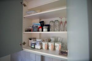 a cupboard with a bunch of mugs on it at Apartments in Kauguri in Jūrmala