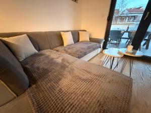 a living room with a couch and a large window at Apartman TERRASSE in Trebinje